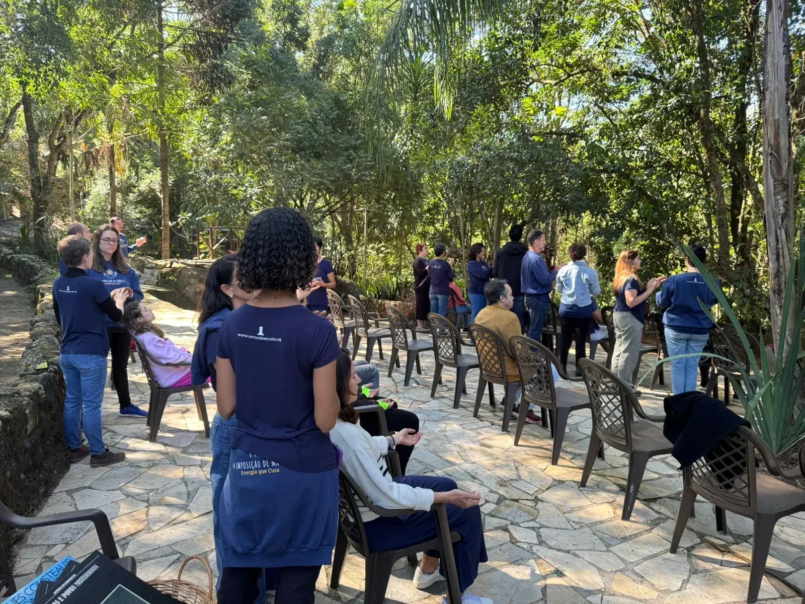 Volunteers attending to seated people in the garden of St. Damian Monastery