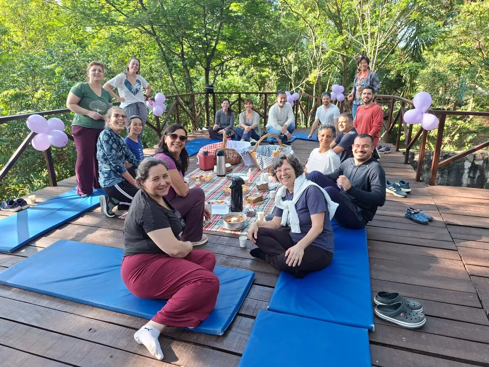 Group sharing a snack on a deck among the trees